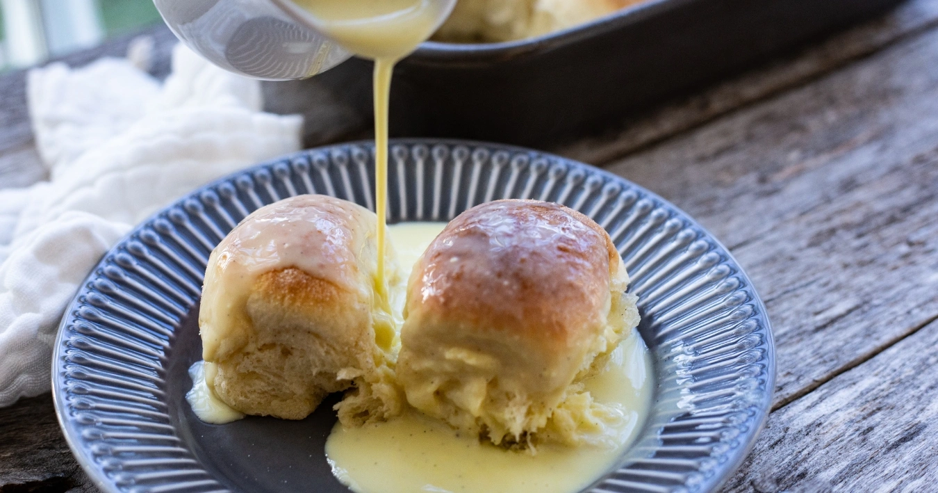 Buchteln Rezept – Flaumige, goldbraun gebackene Hefeteigstücke mit süßer Füllung, serviert mit Vanillesoße.